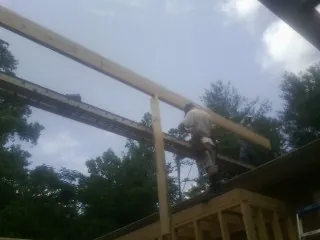 Carpenter setting a ridge beam over a new addition frame — Ice Dam Removal by Roofing Brothers in Boyds