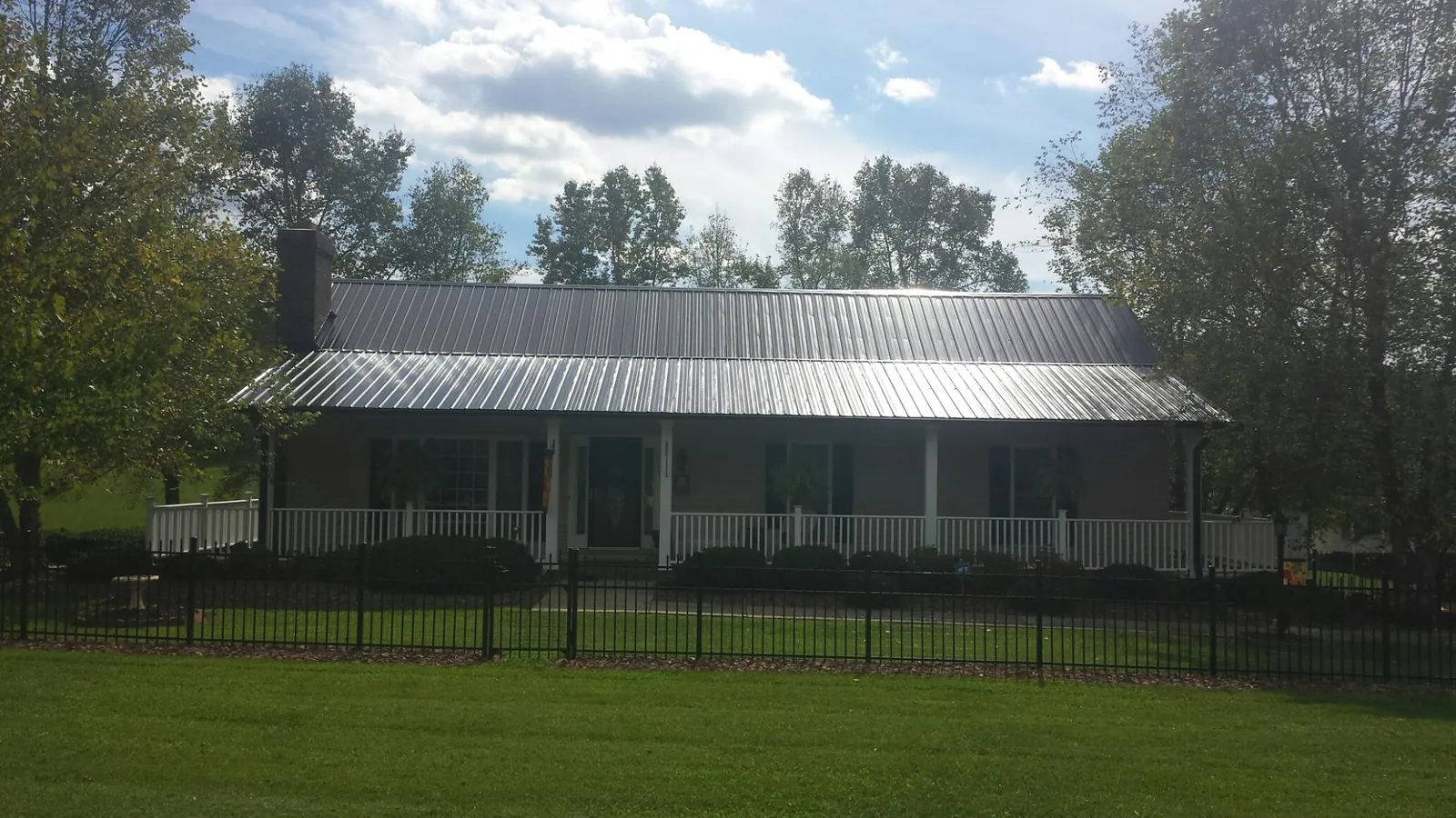 Gray metal roof on a brick ranch with a full width front porch — Gutter Guard Installation work by our crew in Boyds